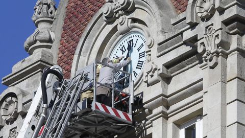 Un operario cambia la hora en el reloj de Maria Pita, en A Coruña