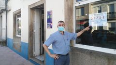 Manuel Dom�nguez, del bar A Quiniela de Zas, con el cartel que acredita el primer premio de la Loter�a Nacional de hoy s�bado, EL 05.751 (inicialmente Loter�as mand� un cartel equivocado acabado en 31)