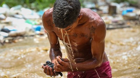 Un joven �minero� busca restos en el r�o Guaire