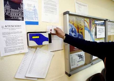 Un funcionario coru��s ficha en la m�quina de la entrada de las dependencias municipales.