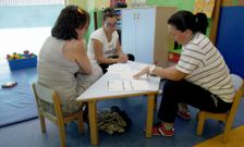 Dos madres conversan con una cuidadora de la escuela rianxeira en la jornada de puertas abiertas. 