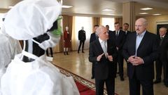 El presidente bielorruso, a la derecha, observa material sanitario