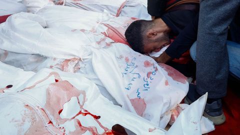 Un hombre abraza los cuerpos de sus familiares muertos en bombardeo israel�es en Rafah.