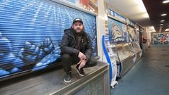 El grafitero O'Ras pinta los puestos de un mercado que los comerciantes urgen que se arregle