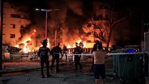 Los bomberos intentan apagar el fuego tras el impacto de un misil iraní en Tel Aviv