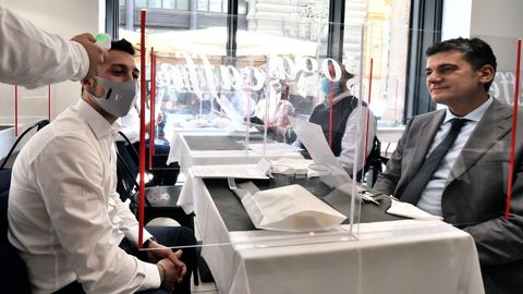 Un camarero le toma la temperatura a un cliente en un restaurante de Mil�n