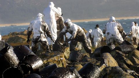Voluntarios recogiendo fuel durante la tragedia del Prestige