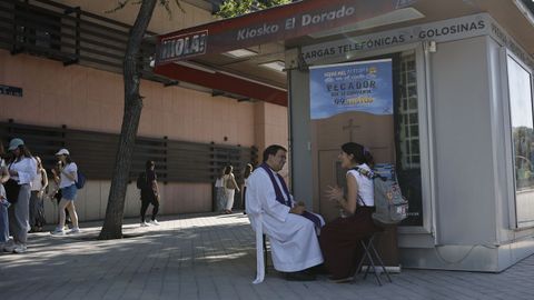 Una feligresa habla con un sacerdote en la plaza San Juan de la Cruz en las horas previas a la Vigilia de Oraci�n con j�venes.