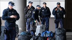 Oficiales de polic�a esperan afuera del aeropuerto, antes de ser transportados a diferentes partes de la frontera entre Nueva Gales del Sur y Victoria, Australia