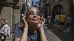 Una turista prueba las gafas homologadas que repartir� la oficina municipal de turismo de Santiago para una visi�n segura del eclipse.