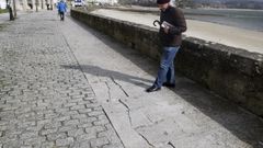 Un vecino posa frente a las losas rotas del paseo.