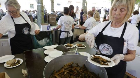 Dos de las voluntarias que cocinan las truchas para el batallón de comensales, este domingo en Ponte Caldelas.