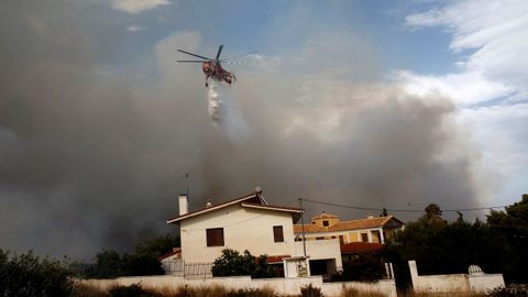 Un helicptero trata de extinguir un incendio en Penelti