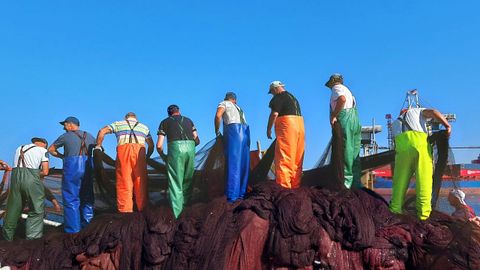 Varios trabajadores preparan los aparejos de pesca en Portugal.