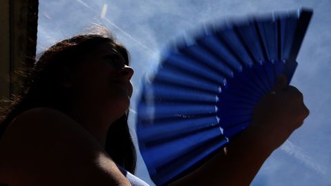Una joven usa un abanico para mitigar las altas temperaturas
