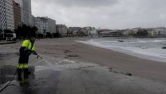 Un operario, esta ma�ana limpiando la arena en el paseo