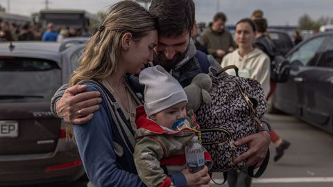 Un hombre da la bienvenida a Anna y a su hijo Svyatoslav, a su llegada a Zaporiyia desde Mariupol.