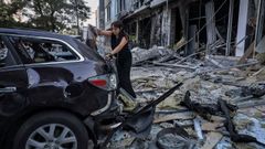 Una mujer inspecciona los daos en un coche tras un ataque ruso en Odesa