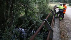 Trabajadores en la tarde del martes junto al cauce fluvial afectado, que desprende fuerte olor a pur�n