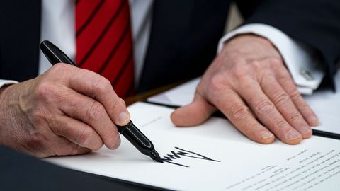 Donald Trump firma una orden ejecutiva en el despacho oval.