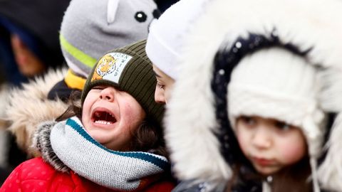 Una madre trata de calmar a su hijo que llora en la frontera entre Polonia y Ucrania