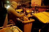 Una pareja de jvenes con dificultades recupera del contenedor comida tirada.