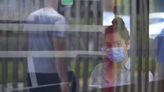Una mujer con mascarilla en el bus que va al HULA