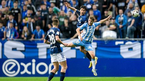 Alonso Aceves salta con Febas, con Bretones de espaldas, durante el Oviedo-Mlaga