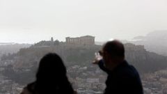 Dos personas contemplan la Acr�polis de Atenas desde un mirador.