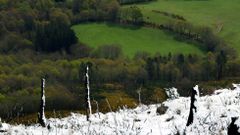 Contraste entre el verde primaveral de los prados de las zonas bajas con la nieve que cay� este viernes en la monta�a de O Faro