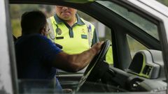 Un guardia civil le hace una prueba de alcoholemia a un conductor en una carretera de Ourense.