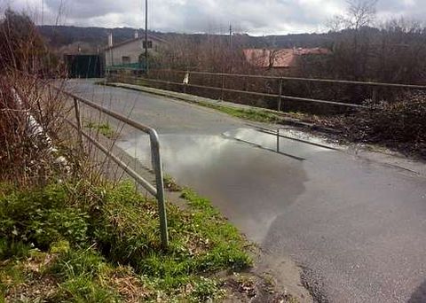 El puente embalsa agua que cae al vial que discurre por debajo.