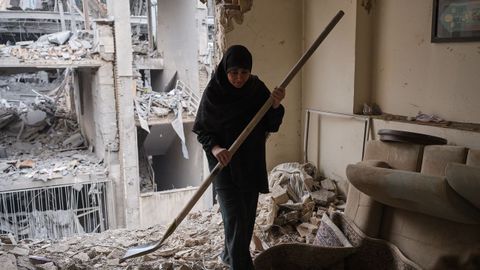 Una mujer trata de limpiar una vivienda en el barrio de Haft Chenar de Teher�n que result� da�ada en un ataque de Estados Unidos e Israel.