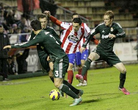 El delantero rojiblanco �scar D�az, con la pelota entre tres jugadores del Castilla.