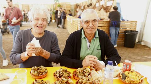 Dos vecinos degustando marisco en la Festa da Ameixa de Campelo.