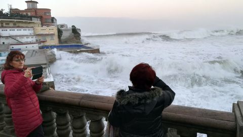 Gijoneses se asoman al Cantábrico, para ver los efectos del temporal Evi, y sacan fotografías junto al Club de Regatas.Gijoneses se asoman al Cantábrico, para ver los efectos del temporal Evi, y sacan fotografías junto al Club de Regatas