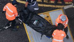 Operarios retiran un cuerpo de uno de los edificios incendiados en Hong Kong.