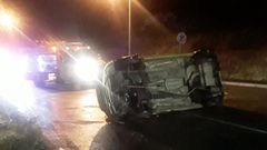 El vehículo accidentado, volcado en la travesía de Pastoriza