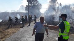 Un guardia civil habla con un vecino de Centulle en la zona afectada por el incendio