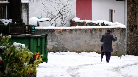 Una persona camina por una calle nevada en San Juan de Bele�o, Ponga