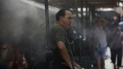 Un hombre en medio de vaporizadores de agua en Atenas