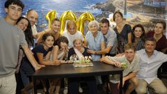Pilar Fern�ndez, sentada en el centro, junto a la tarta con las velas que indican que acaba de cumplir un siglo de vida. 
