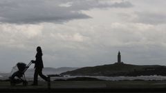 Una mujer camina por el paseo mar�timo de A Coru�a en una jornada lluviosa.