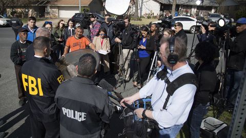Agentes de polic�a y reporteros, en el vecindiario donde se produjo la tercera explosici�n, en Austin