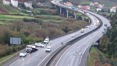 Operarios retirando uno de los veh�culos y la Guardia Civil regulando el tr�fico en la AG-55