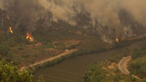 El incendio cerca de Alvaredos, con la vía del tren a la izquierda del Sil y la carretera N-120 a la derecha