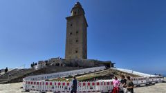 Visitantes al pie de la torre de H�rcules, en la que hay una zona vallada con una zanja desde marzo