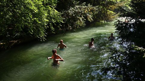 Varias personas nadan en el arroyo Eisbach en el Jard�n Ingl�s de M�nich (Alemania).