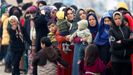 Mujeres y ni�os hacen cola para recibir comida en el paso turco de Pazarkule,  donde se hacinan varios miles de migrantes
