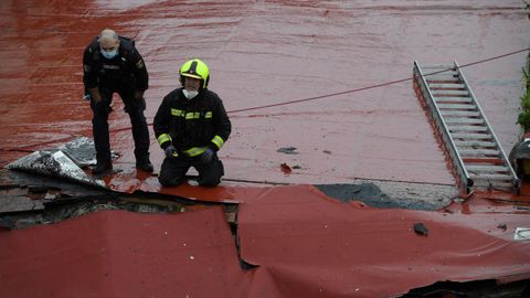 Un bombero y un agente de la Polica Nacional trabajan en la azotea del colegio San Vicente Pal en Gijn